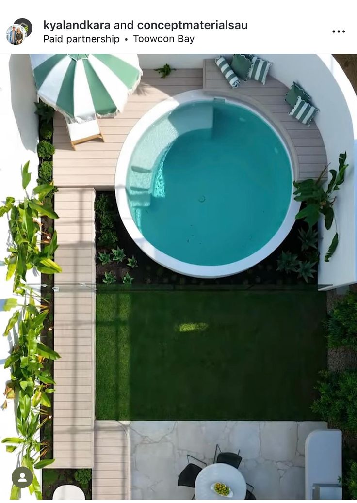 an aerial view of a backyard with a pool and patio furniture in the middle of it