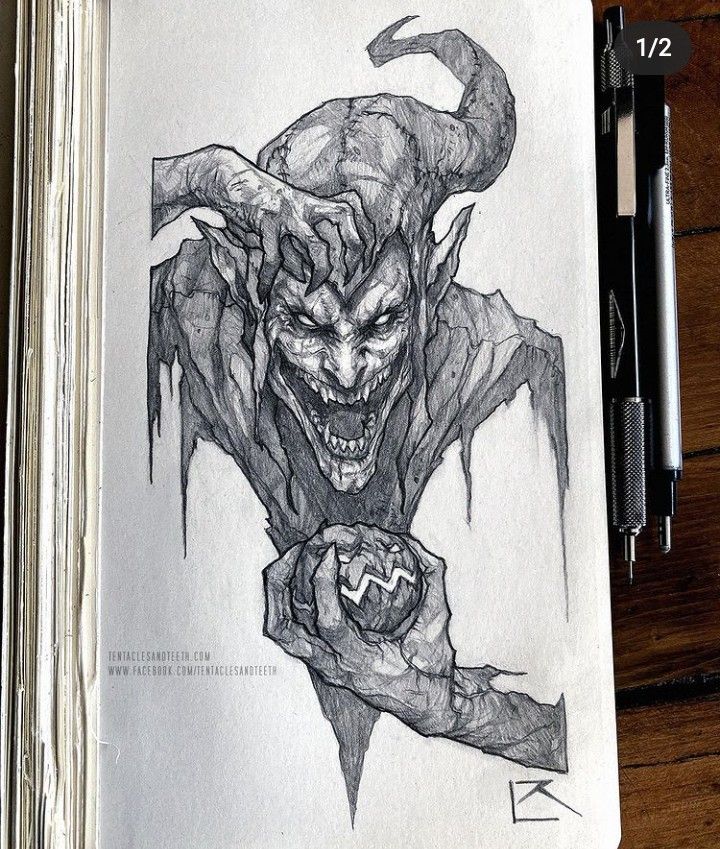 a drawing of a demonic demon with horns and fangs on it's face, in a notebook