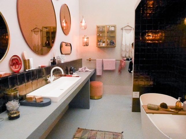 a bathroom with two sinks and three mirrors on the wall next to a bathtub