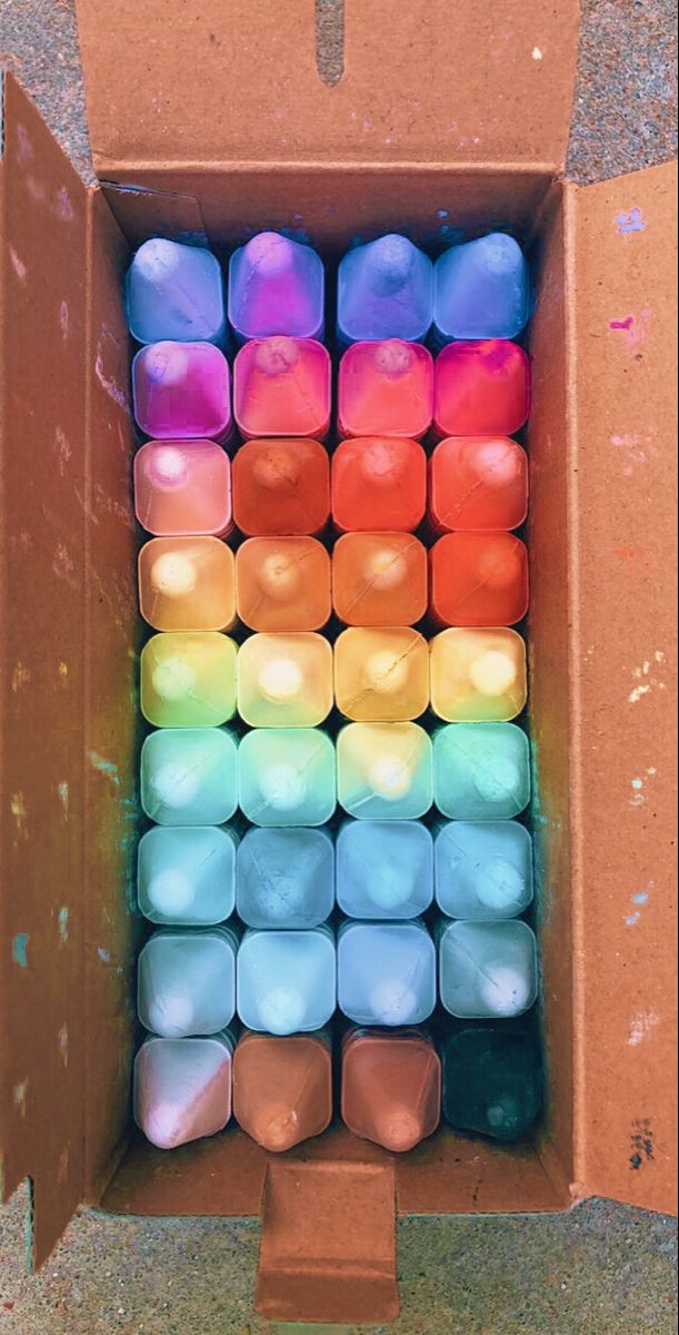 a box filled with lots of different colored candles