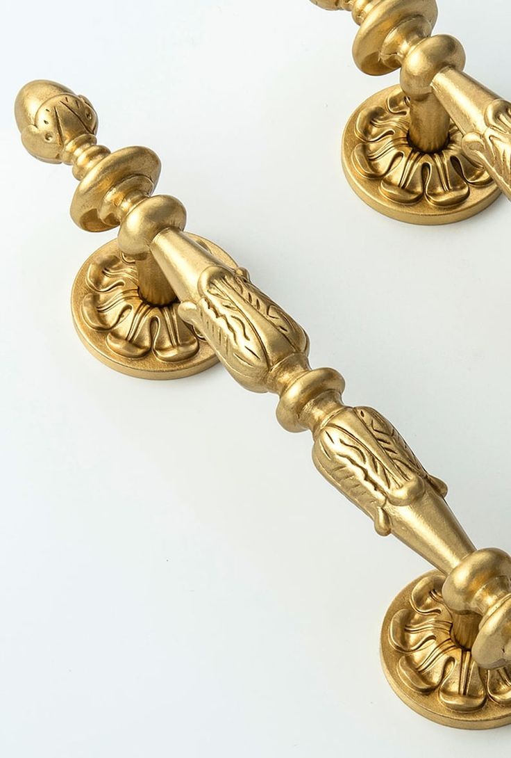 two golden door handles on a white background