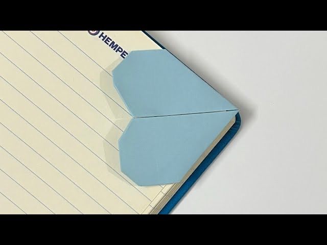 an origami piece of paper on top of a notepad with the word home written on it