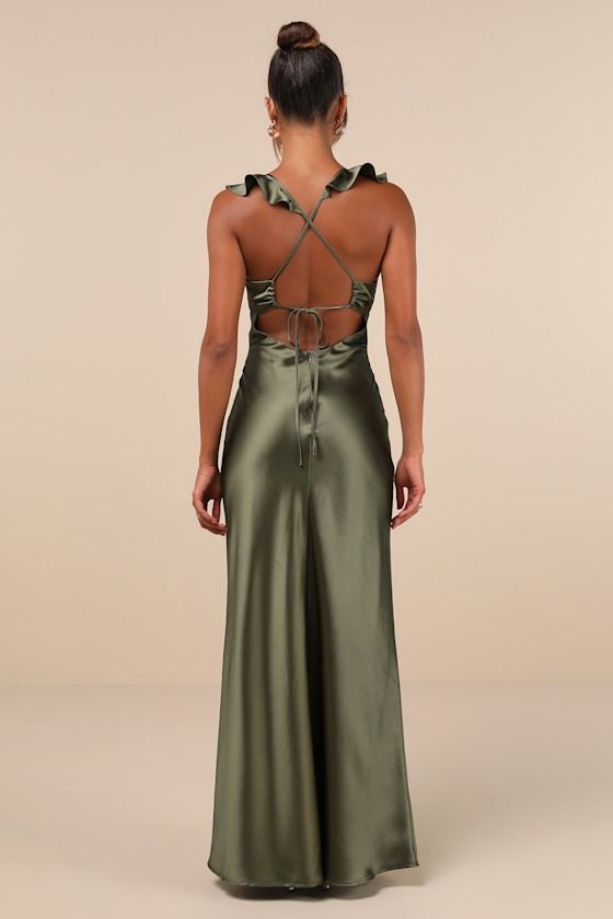 the back of a woman wearing a green dress with cut outs and straps on it