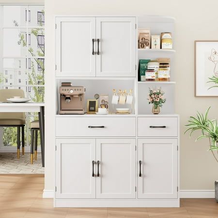 a white bookcase with many books on it in a living room next to a dining room table