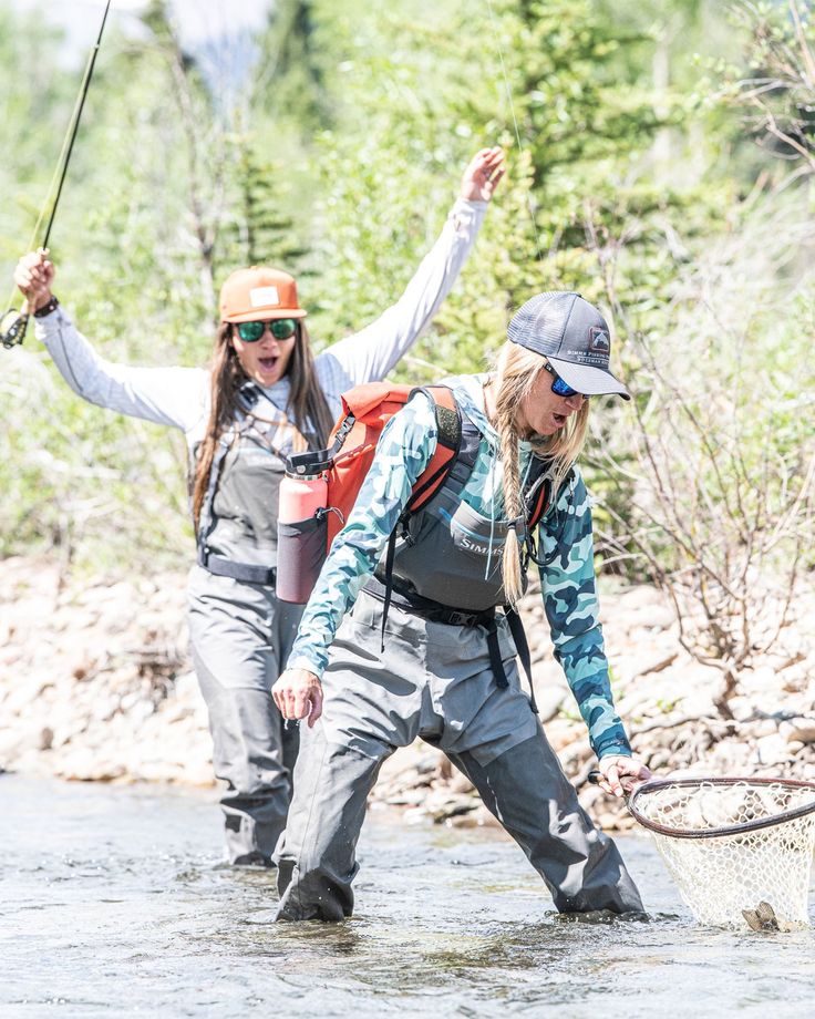 two women fly fishing in the river together