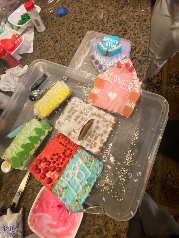 there are many different cakes in the plastic container on the table with utensils