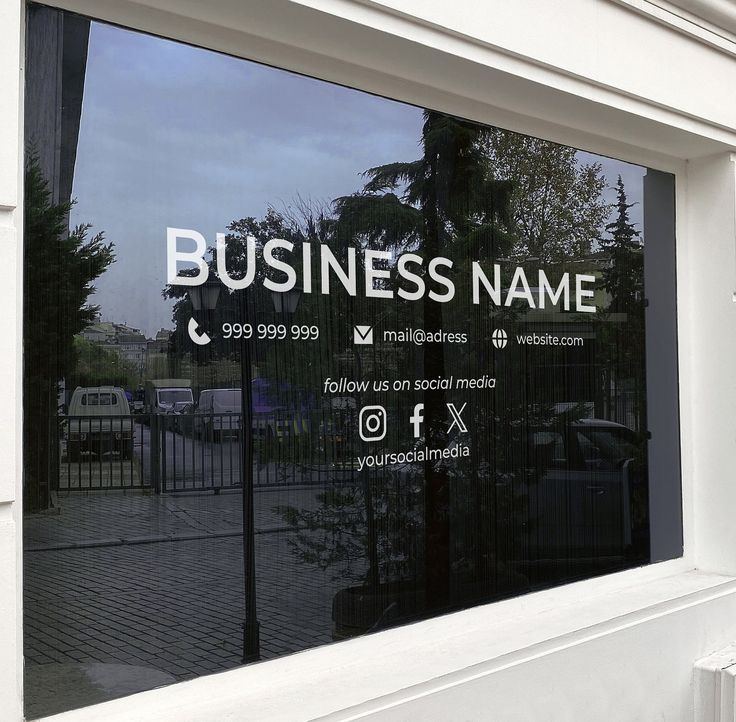 a business sign is reflected in the window of a building