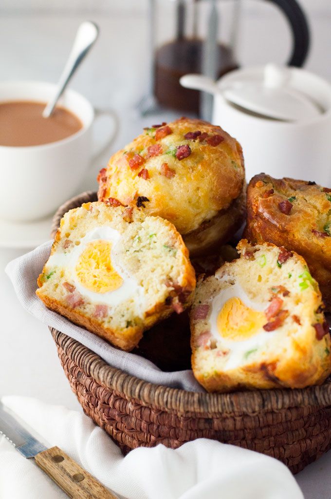 breakfast muffins in a basket next to a cup of coffee