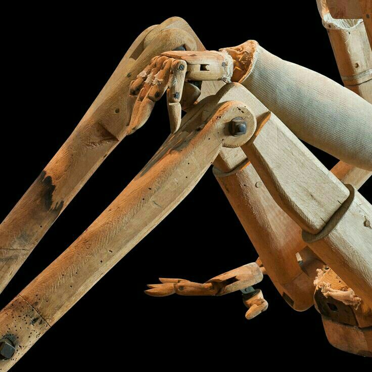 a close up of a wooden structure with hands and legs