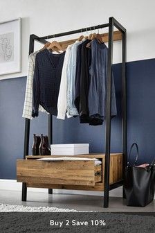 a clothes rack with some shirts hanging on it and a handbag next to it