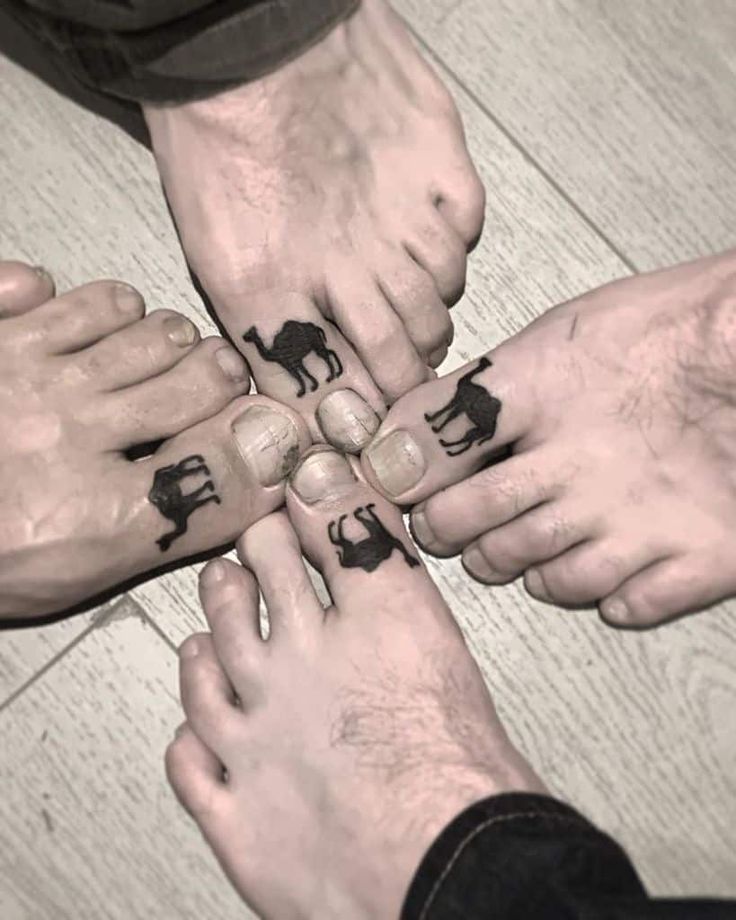 four people are holding hands with tattoos on their palms and elephants drawn on the fingers