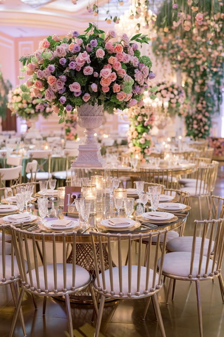 an elegant wedding reception with tall centerpieces and pink flowers on the table top