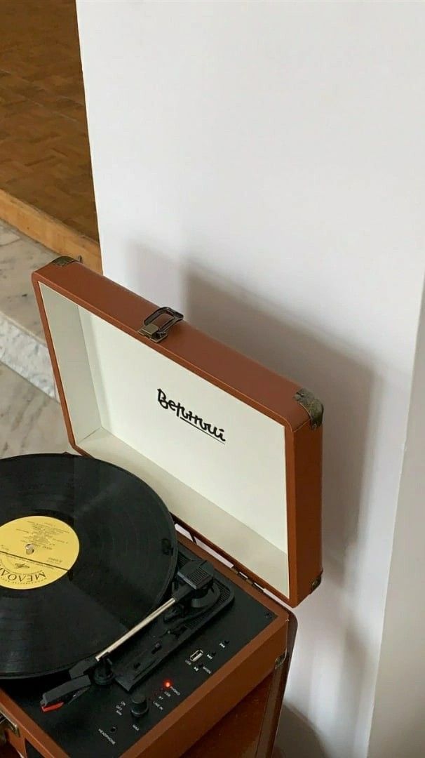 an old record player sitting on top of a table