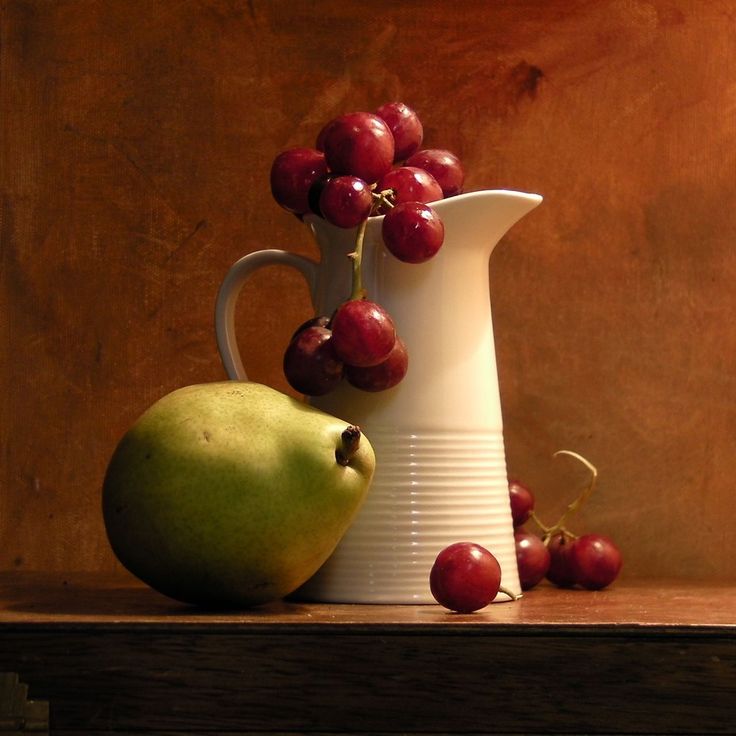 a painting of a pitcher, pear and cherries on a table with brown background