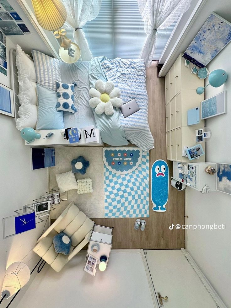 an aerial view of a bedroom with blue and white decor on the walls, bedding, and pillows