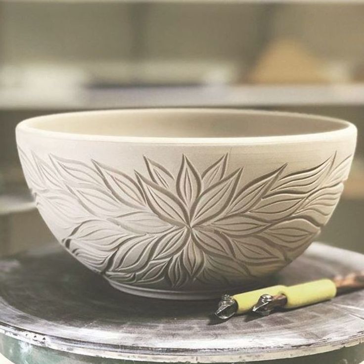 a white bowl sitting on top of a table next to a yellow marker and pen