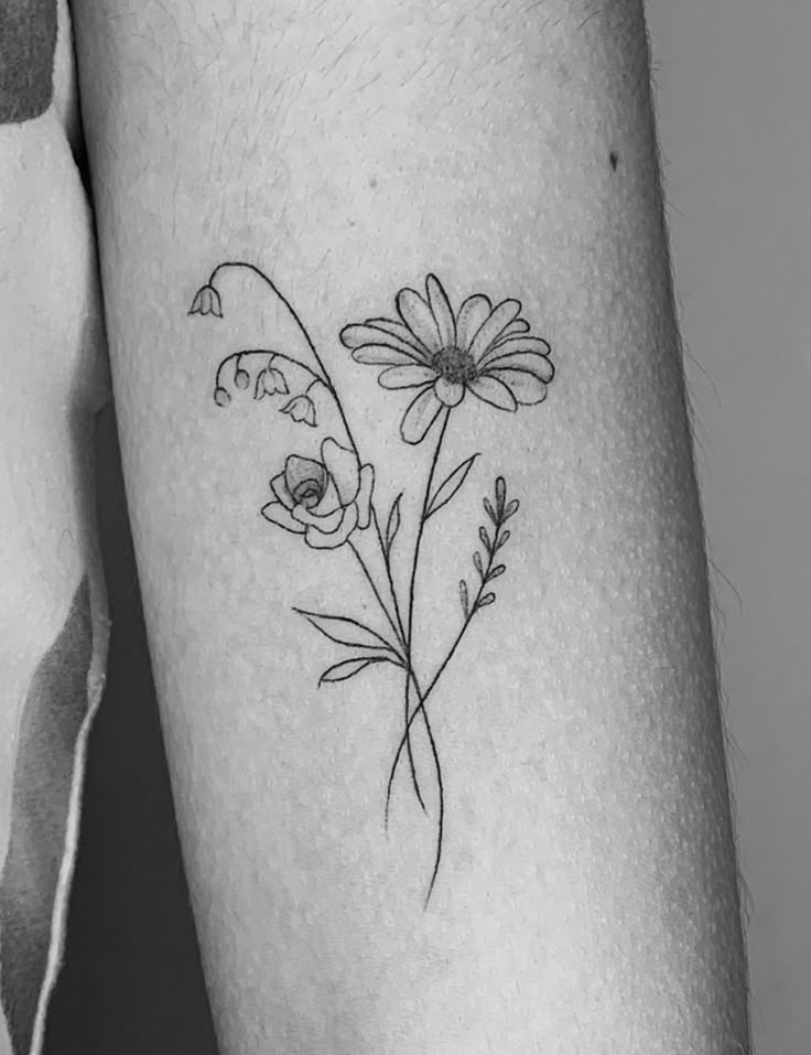 a black and white photo of a flower tattoo