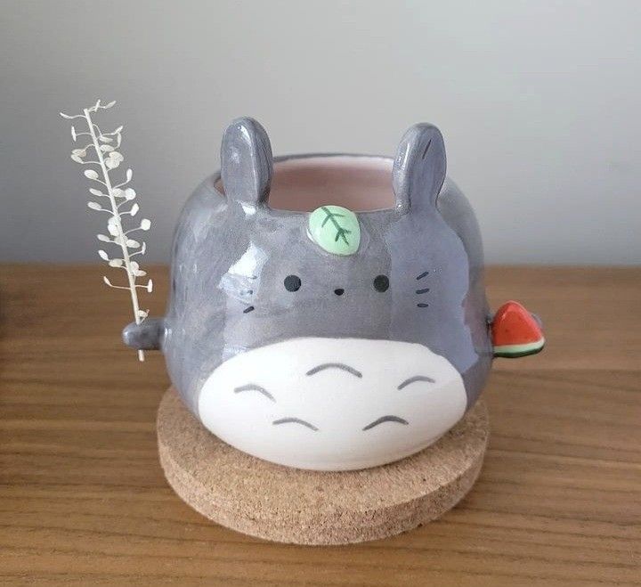 a ceramic animal planter sitting on top of a wooden table next to a watermelon