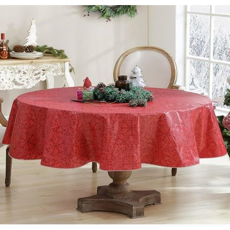 a red table cloth on top of a wooden table in front of a christmas tree