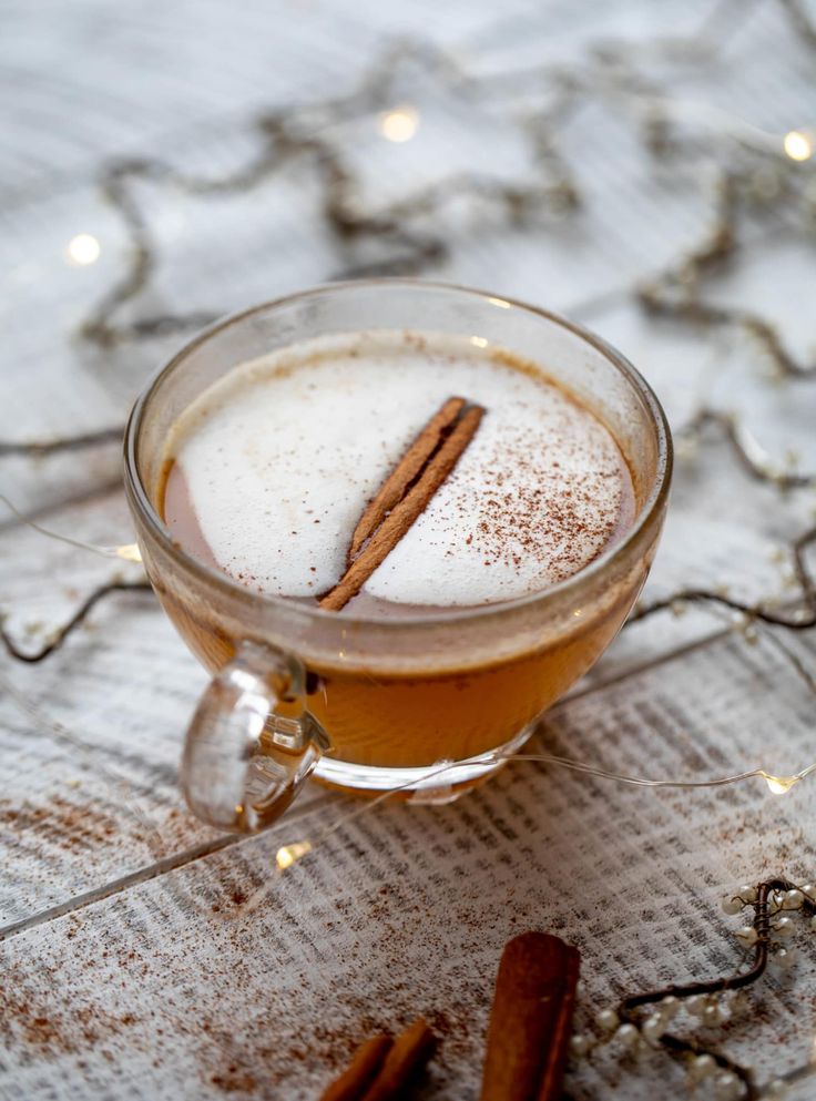 a glass mug filled with liquid and cinnamon sticks