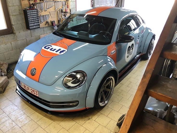 a blue car with an orange stripe on it's side parked in a garage