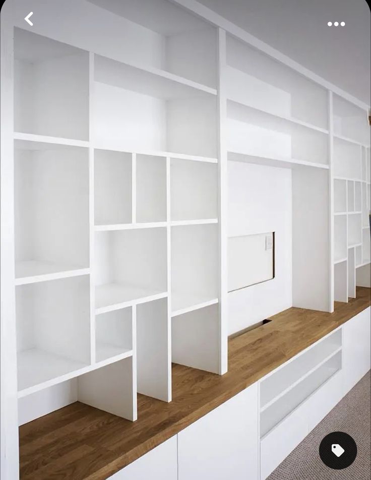 white bookcases line the wall in an empty room