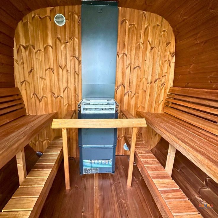 the inside of a wooden sauna with benches and an oven on it's side