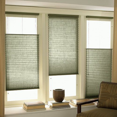 a living room filled with furniture and windows covered in blinds