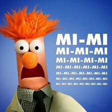 an orange haired man wearing a suit and tie with the words mi - mi in front of him