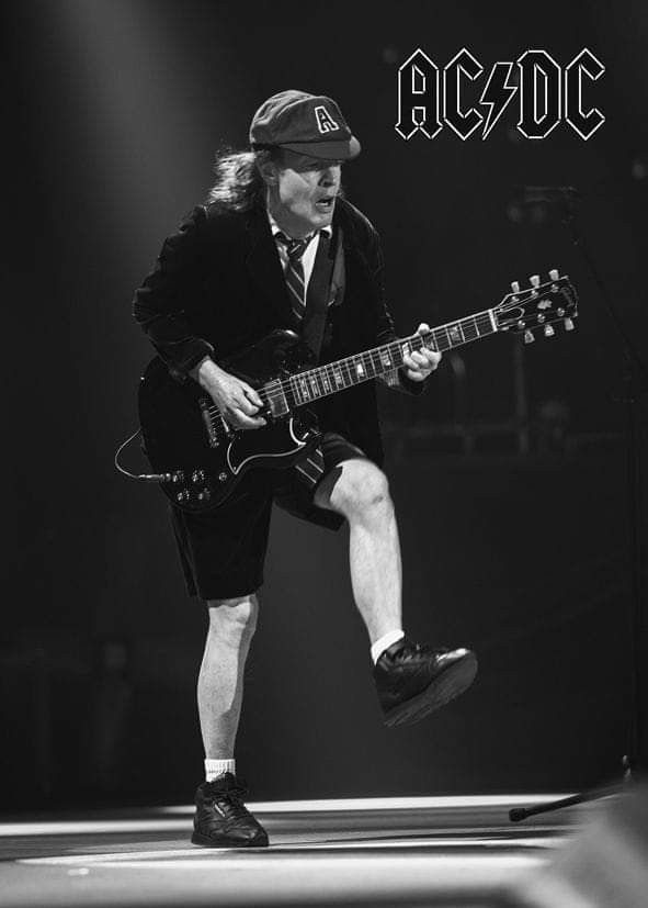 a man playing an electric guitar on stage with the words ac / dc above him