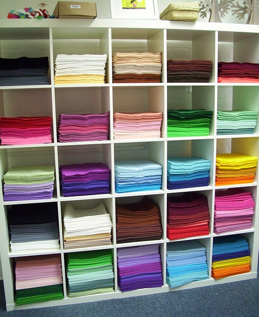 the shelves are filled with many different colored papers