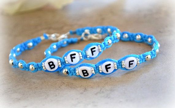 two blue bracelets with letters on them