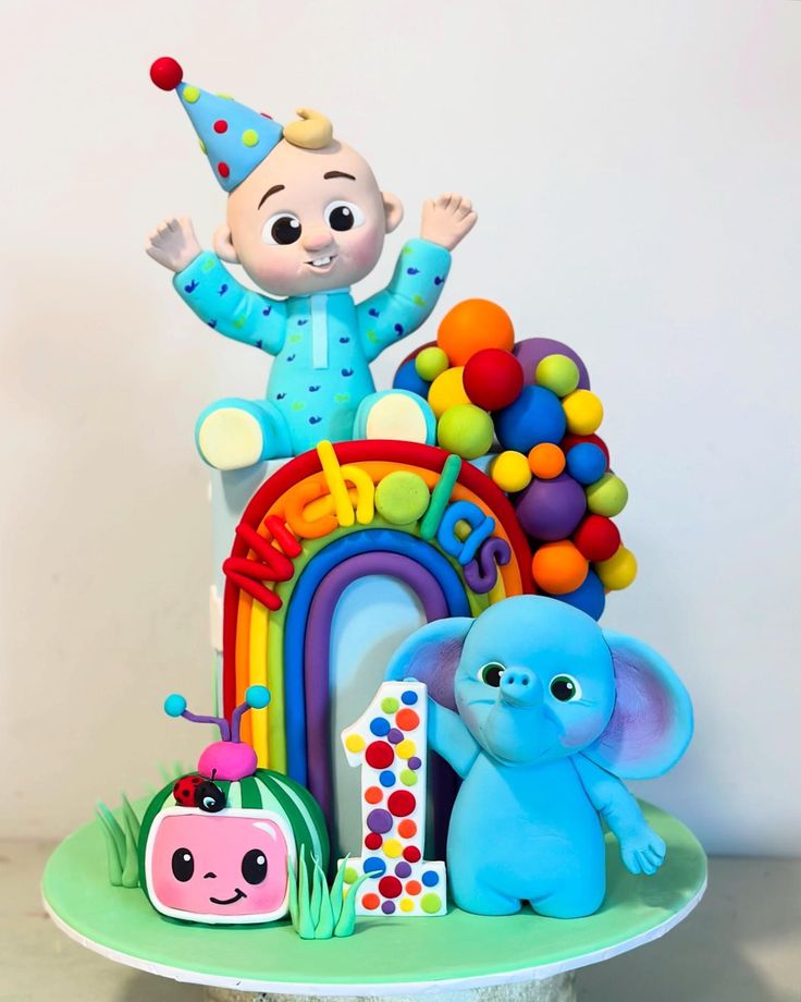 there is a birthday cake with an image of a baby on top and balloons in the air