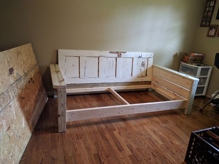 a bed frame made out of wood with no headboard and foot board on the floor