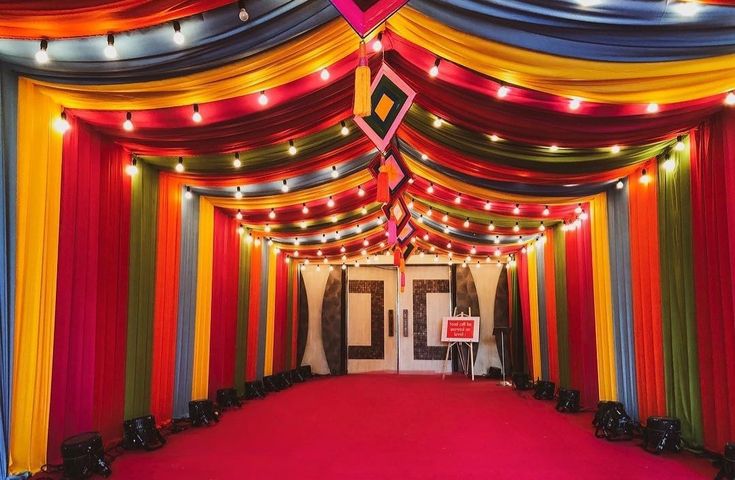 a red carpeted room with colorful drapes and lights