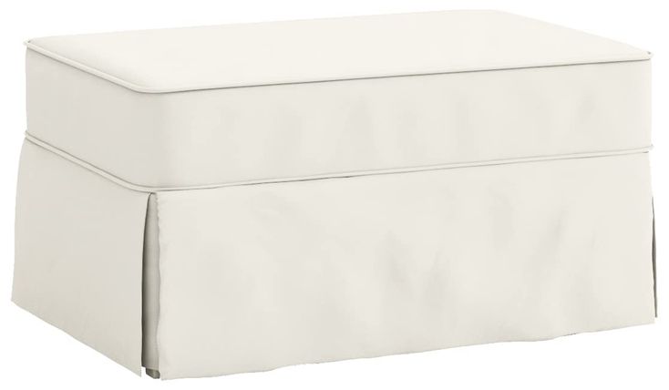 a white ottoman with a cover over it