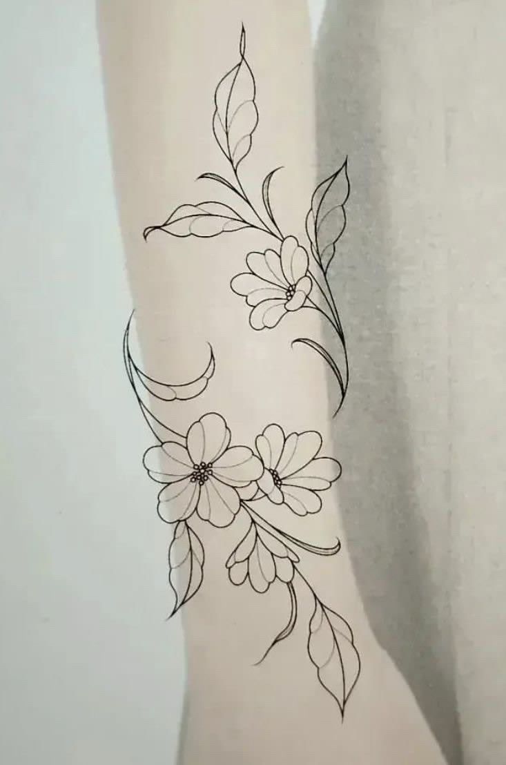 a woman's arm with flowers and leaves tattoo on the left side of her body