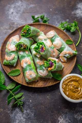 some food is on a plate with sauces and green leafy leaves next to it