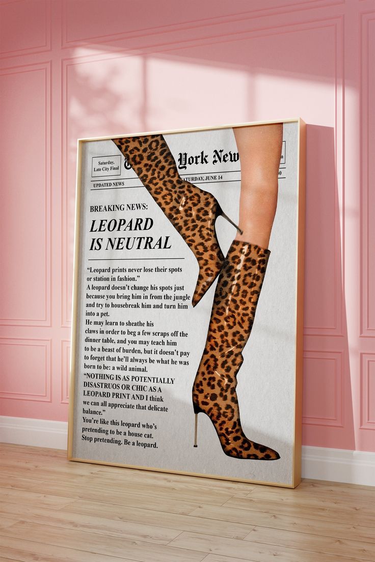 a poster with a leopard print on it in front of a pink wall and wooden floor