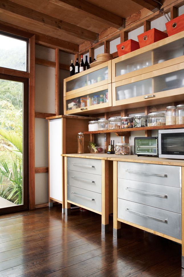 a kitchen with wooden floors and open cabinets