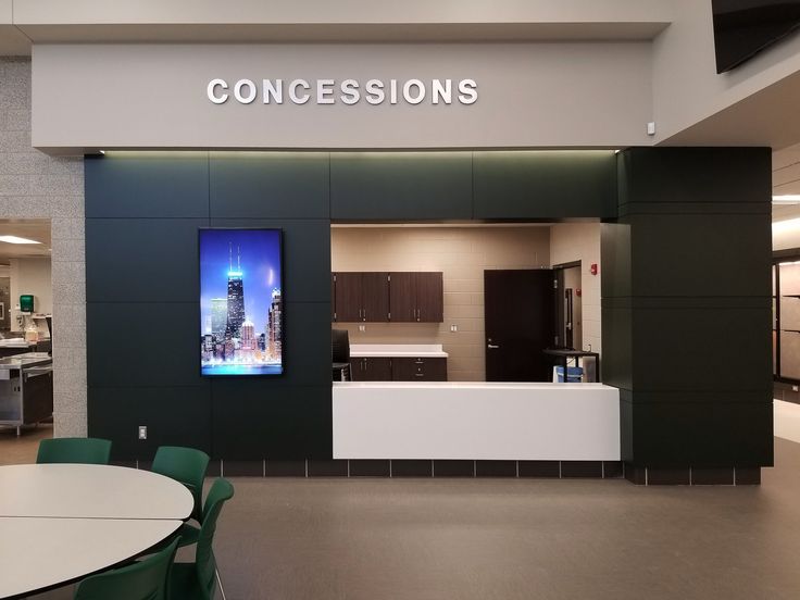 an empty room with tables and chairs in front of a sign that says concessions