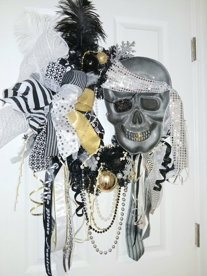 a door decorated with black, white and gold decorations including a skull mask on the front door