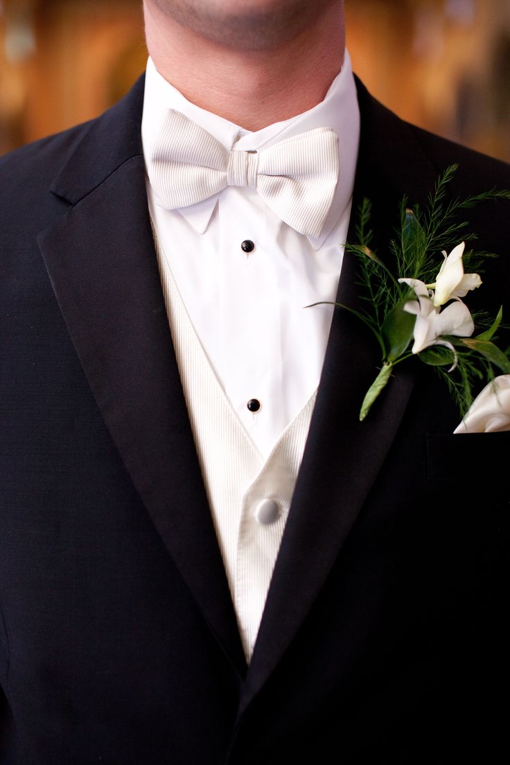 a man in a tuxedo with flowers on his lapel