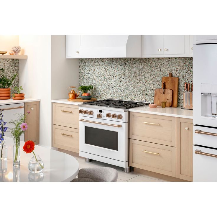 a white stove top oven sitting inside of a kitchen next to a dining room table