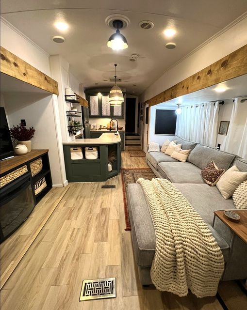 a living room filled with furniture and a flat screen tv on top of a wooden floor