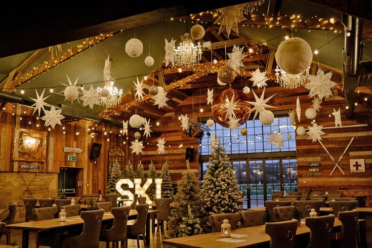 an indoor restaurant decorated for christmas with lights and snowflakes hanging from the ceiling