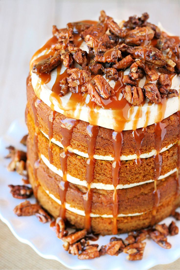 a cake with pecans on top and caramel drizzled over it