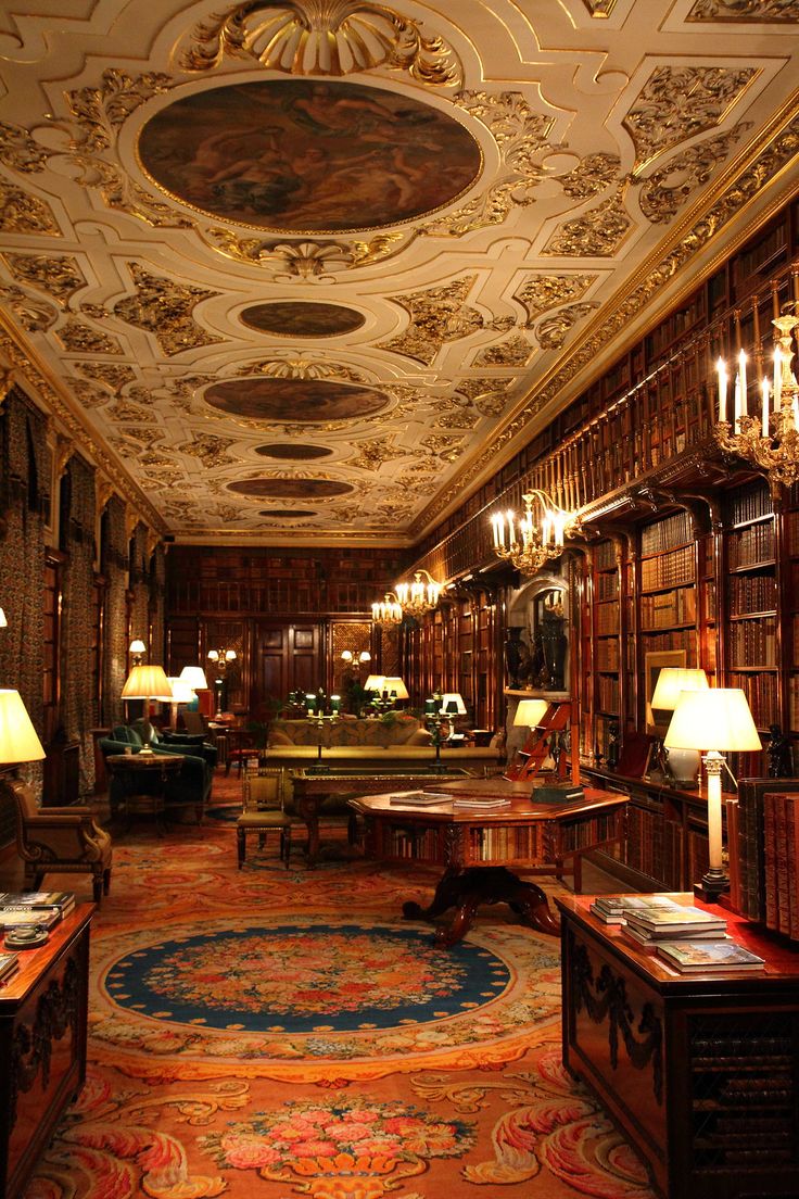 a room with many tables and lamps on the walls, along with bookshelves