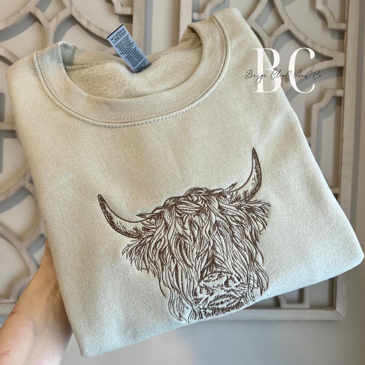 This aesthetic highland cow sweatshirt is the perfect blend of rustic chic.  ❥ Sweatshirt Details: * Crewnecks are ADULT, UNISEX Gildan sweatshirts * 50% cotton/50% polyester * They may shrink a little after washed! We recommend to size-up if you want a more comfortable/oversized look * Please review the size guide for measurement information on each listing photo ❥ Ordering:  * Choose crewneck color and size at checkout * Let us know what thread color you would like in the personalization area, Highland Cow Face, Scottish Cows, Cow Sweater, Scottish Cow, Chic Sweatshirt, Cow Face, Sweatshirt Details, Highland Cows, Embroidered Crewneck