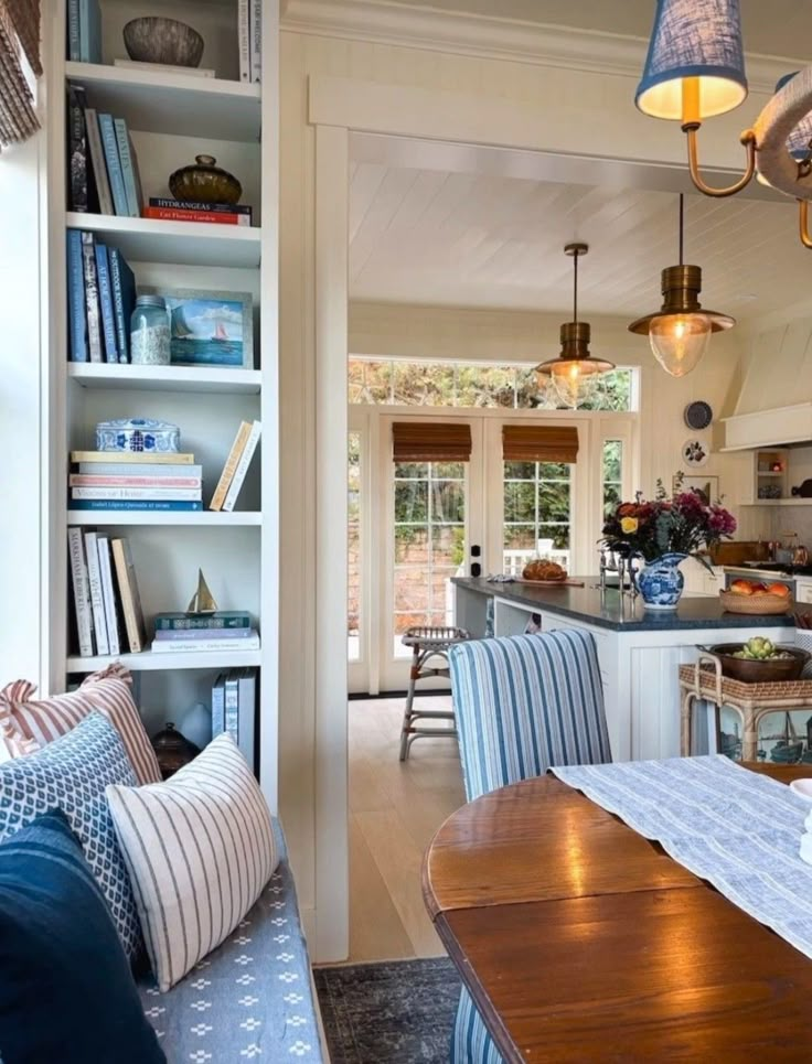 an open kitchen and dining room area with bookshelves